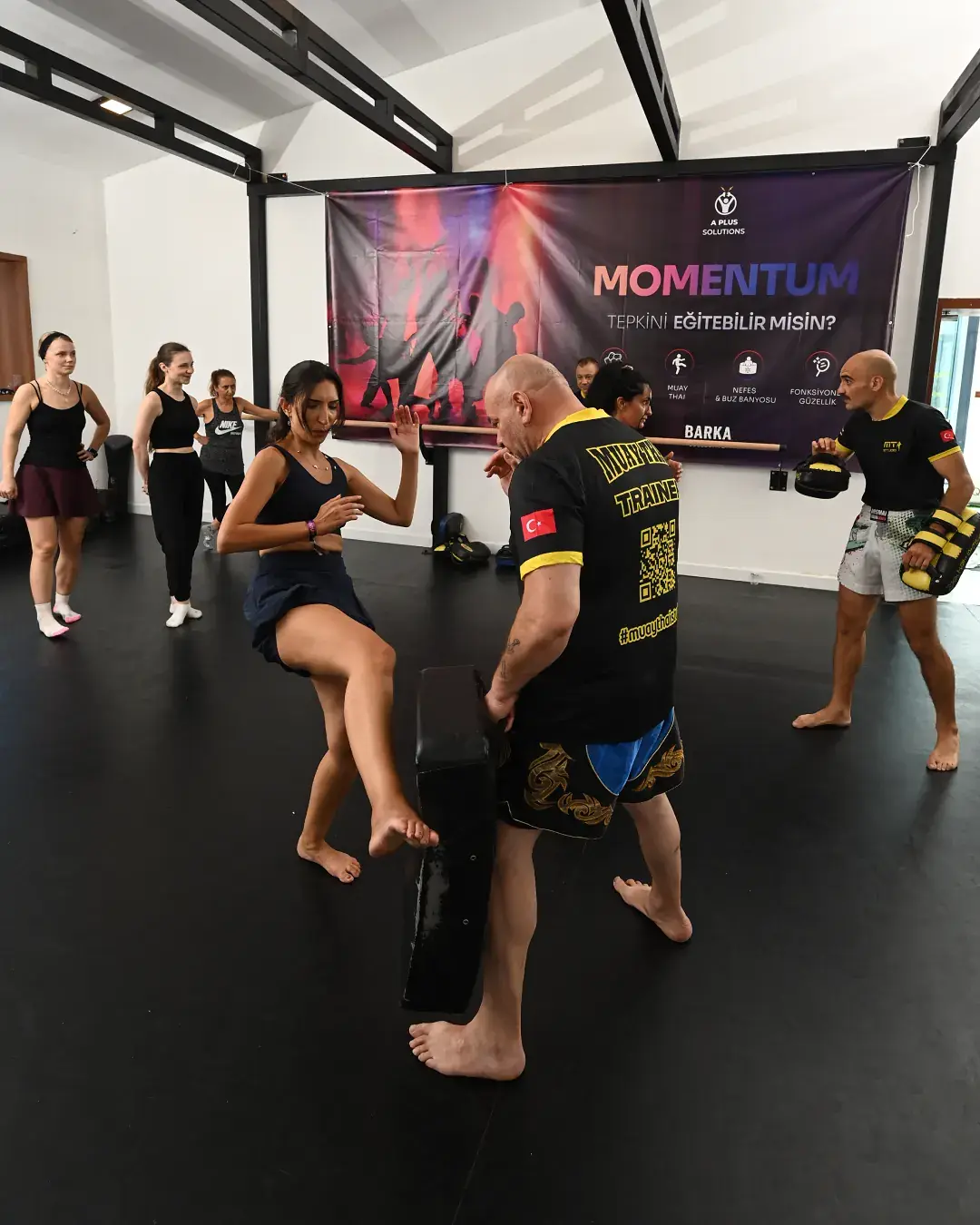 Pad tutan eğitmene tekme atan muay thai katılımcısı