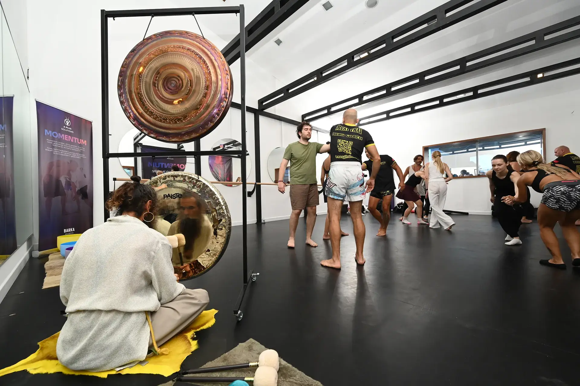 Önde gong çalan eğitmen, arkada muay thai ve hareket grupları